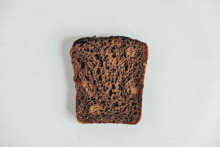 Sliced of brown bread with butter on a white wooden background. Top view. Copy, empty space for text.の写真素材