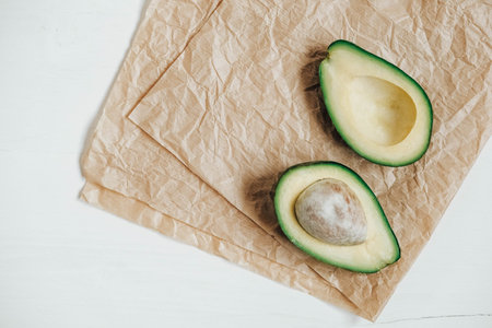 Sliced avocado on a white wooden background. Copy, empty space for text.の写真素材