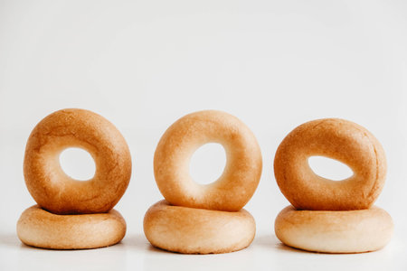 Drying or mini round bagels on a white wooden background. Copy, empty space for text.