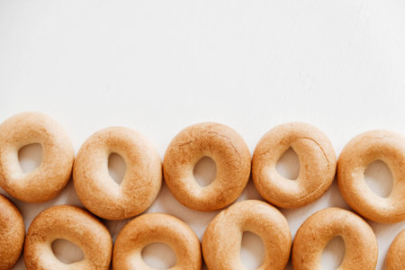 Drying or mini round bagels on a white wooden background. Copy, empty space for text.