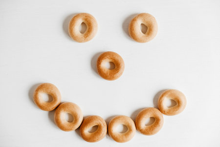 Drying or mini round bagels on a white wooden background. Copy, empty space for text.