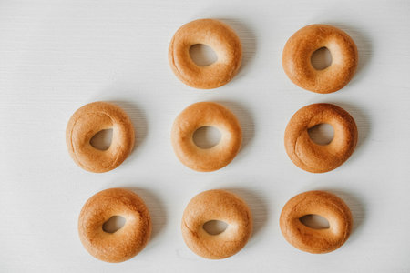 Drying or mini round bagels on a white wooden background. Top view. Copy, empty space for text.