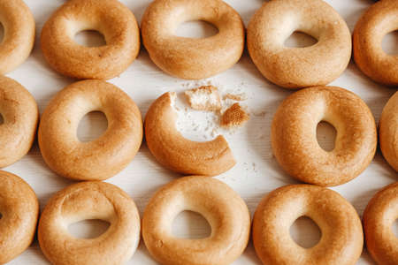 Drying or mini round bagels on a white wooden background. Top view. Copy, empty space for text.の写真素材