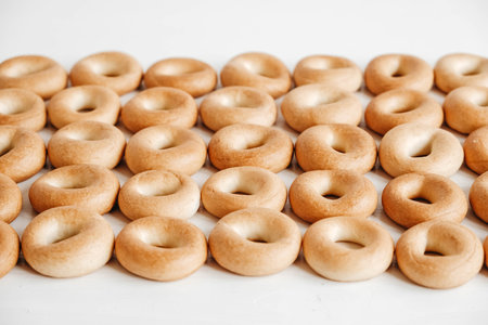 Drying or mini round bagels on a white wooden background. Top view. Copy, empty space for text.の写真素材