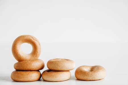 Drying or mini round bagels on a white wooden background. Copy, empty space for text.