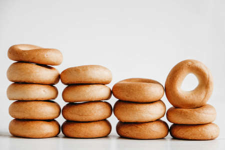 Drying or mini round bagels in the shape of a tower on a white wooden background. Copy, empty space for text.の写真素材