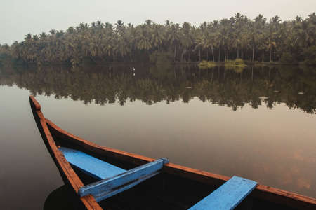 Wooden boat on the backwater canals on a background of tropical forest with palm trees. Copy, empty space for text.の写真素材