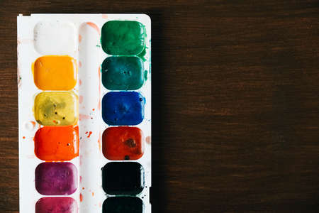 Set of watercolor paints and brushes for painting on a white background. Top view. Copy, empty space for text.の写真素材
