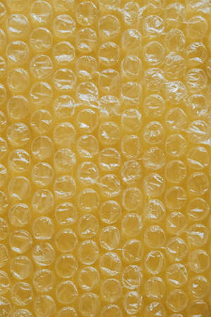 Packaging with air bubbles on a yellow background.  Top view. Copy, empty space for text.の写真素材