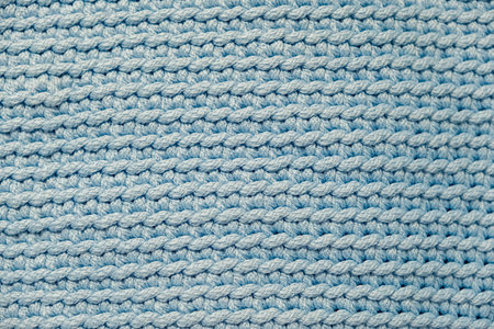 Light soft blue knitted fabric texture background. Top view. Copy, empty space for text.