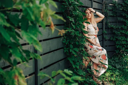 Portrait of a beautiful blonde girl with natural beauty in a green leaves trees. Copy, empty space for text.の写真素材