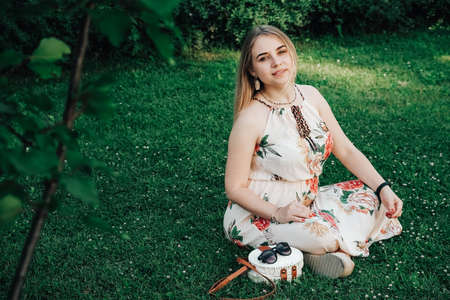 Portrait of a beautiful blonde girl with natural beauty in a green leaves trees. Copy, empty space for text.の写真素材