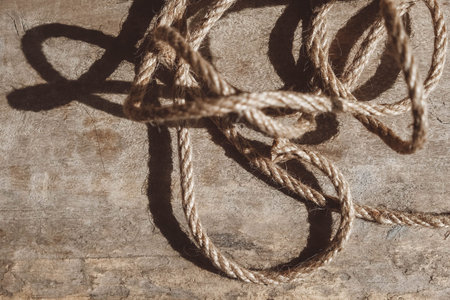 Thick rope on old wooden background. Top view. Copy, empty space for text ..