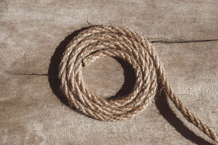 Thick rope on old wooden background. Top view. Copy, empty space for text ..の写真素材