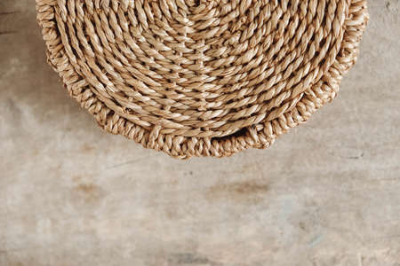 Details of a round wicker basket on an old wooden background. Top view. Copy, empty space for text.の写真素材