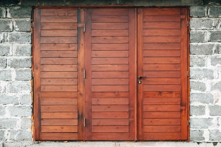 Red wooden gate in a brick wall. Copy, empty space for text.の写真素材