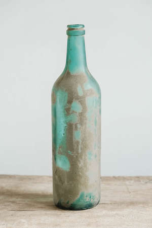Empty glass bottle in pollen and dirt on a wooden table. Copy, empty space for text.の写真素材