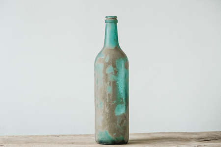 Empty glass bottle in pollen and dirt on a wooden table. Copy, empty space for text.の写真素材