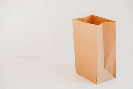 Closed disposable package made of brown kraft paper on a white background. Copy, empty space for text.の写真素材
