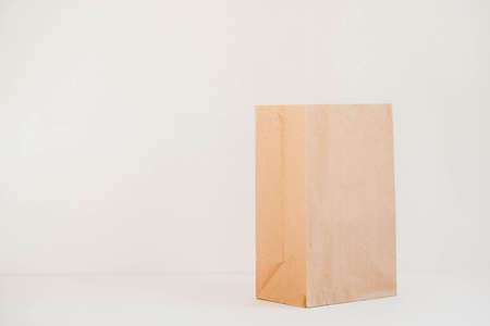 Closed disposable package made of brown kraft paper on a white background. Copy, empty space for text.の写真素材