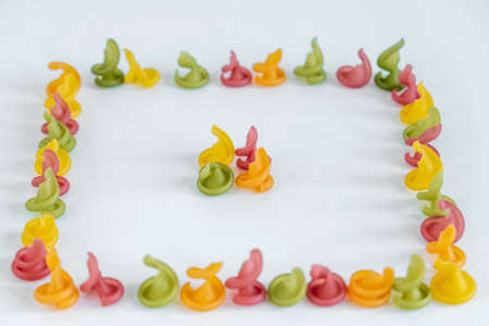 Multicolored pasta in the shape of a square on a white background. Top view. Copy, empty space for text.の写真素材