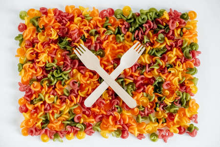 Multicolored pasta with a wooden forks as a background image. Top view. Copy, empty space for text.の写真素材