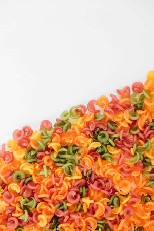 Multicolored pasta scattered on a white background. Top view. Copy, empty space for text.の写真素材
