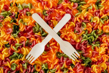 Multicolored pasta with a wooden forks as a background image. Top view. Copy, empty space for text.の写真素材