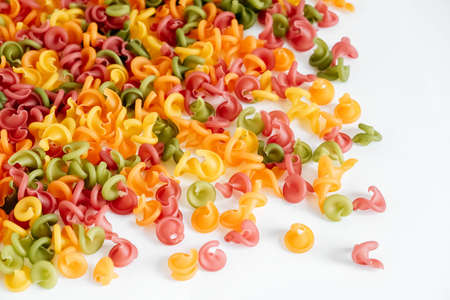 Multicolored pasta scattered on a white background. Top view. Copy, empty space for text.の写真素材