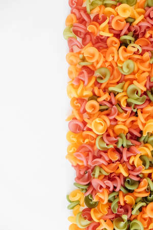 Multicolored pasta scattered on a white background. Top view. Copy, empty space for text.の写真素材