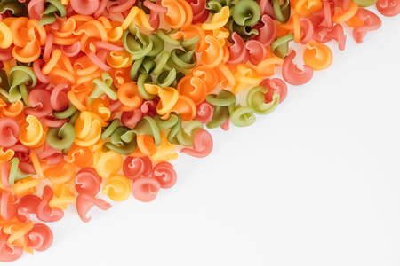 Multicolored pasta scattered on a white background. Top view. Copy, empty space for text.の写真素材