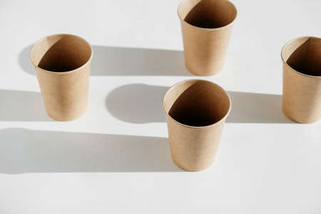 Disposable paper cups with shadow from light on white background. Copy, empty space for text.の写真素材