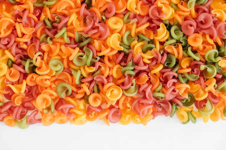 Multicolored pasta scattered on a white background. Top view. Copy, empty space for text.の写真素材