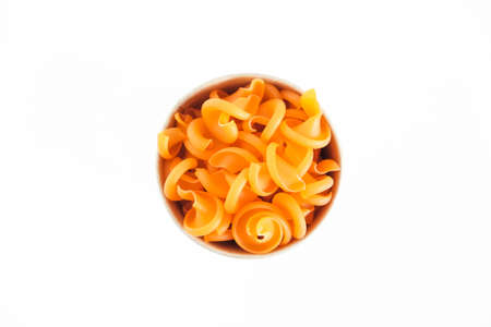 Orange pasta in a disposable kraft paper cup on a white background. Top view. Copy, empty space for text.の写真素材