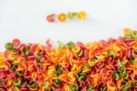 Multicolored pasta scattered on a white background. Top view. Copy, empty space for text.の写真素材