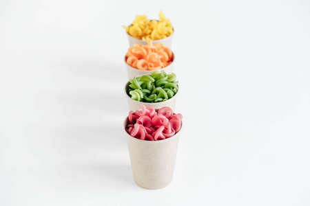 Multicolored pasta in a disposable kraft paper cups scattered on a white background. Top view. Copy, empty space for text.の写真素材