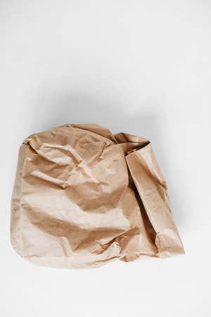 Full crumpled disposable bag of brown kraft paper on a white background. Top view. Copy, empty space for text.の写真素材