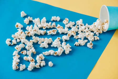 Popcorn in blue paper cups on a yellow and blue background. Top view. Copy, empty space for text.の写真素材