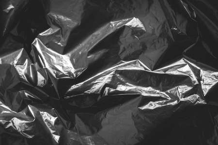 Black crumpled plastic film as a background texture image. Top view. Copy, empty space for text.の写真素材