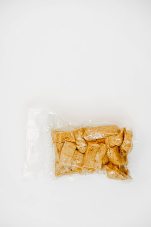Tofu with spices in a plastic package on a white background. Top view. Copy, empty space for text.の写真素材