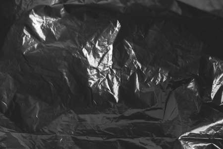 Black crumpled plastic film as a background texture image. Top view. Copy, empty space for text.の写真素材