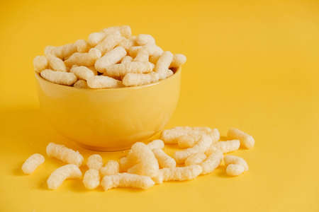 Corn sticks in a yellow bowl on a yellow background. Copy, empty space for text.の写真素材