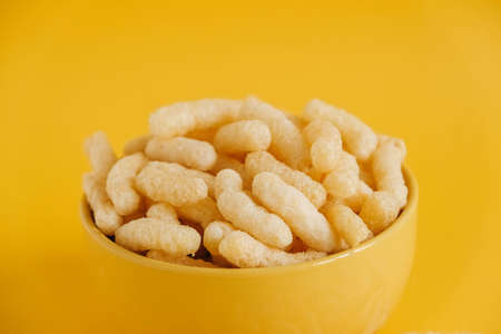 Corn sticks in a yellow bowl on a yellow background. Copy, empty space for text.の写真素材