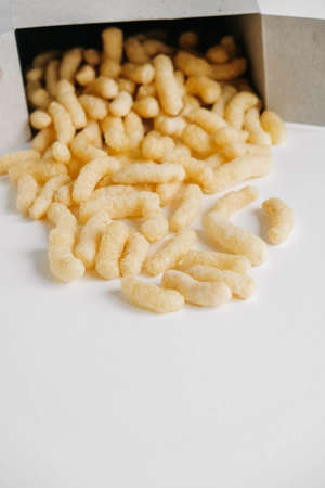 Corn sticks in paper box scattered on a white background. Top view. Place for your text.の写真素材