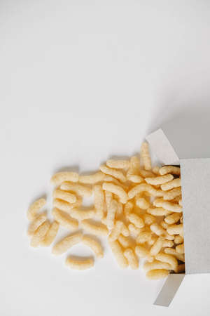 Corn sticks in paper box scattered on a white background. Top view. Place for your text.の写真素材