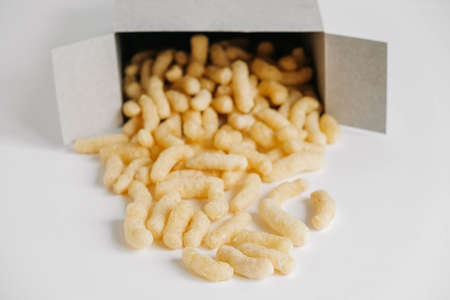 Corn sticks in paper box scattered on a white background. Top view. Place for your text.の写真素材