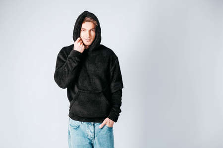 Man in a light T-shirt and jeans on a white background. Copy, empty space for text.の写真素材