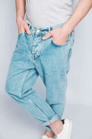 Man in a light T-shirt and jeans on a white background. Copy, empty space for text.の写真素材