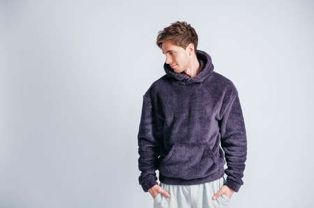 Young muscular man in a light T-shirt and black jeans on a white background. Copy, empty space for text.の写真素材