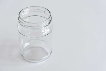 Empty glass transparent jar on a white table. Copy, empty space for text.の写真素材